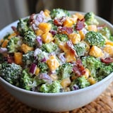 A bowl filled with broccoli topped with cheese and bacon.