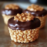 Three mini chocolate cups with creamy peanut butter topping.